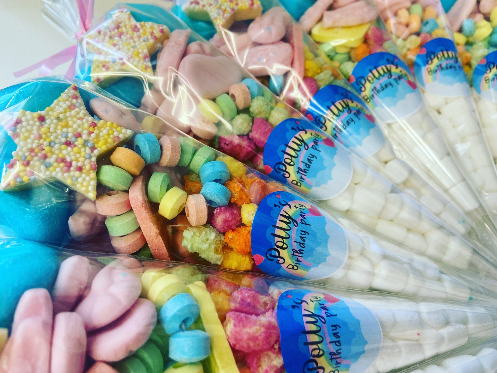 Pastel-colored sweets and candies displayed in decorative jars and trays on a baby shower table with soft decorations and a gentle, joyful atmosphere.