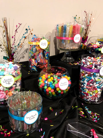 Assorted sweets and chocolates arranged on a table with blue and silver decorations for a Bar Mitzvah celebration. The environment is festive and welcoming.